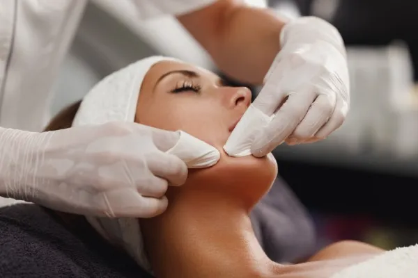 Facial treatments, a doctor's hand trying to squeeze mud out of a woman's face.