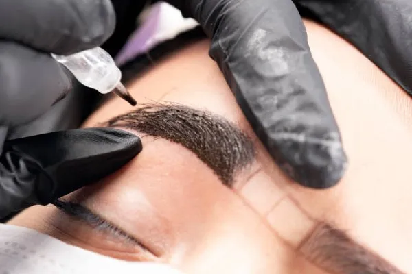 How much is microblading; close-up of a person's eyebrow during the procedure