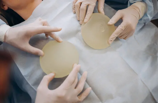 Surgeons preparing breast implants before a breast lift operation.