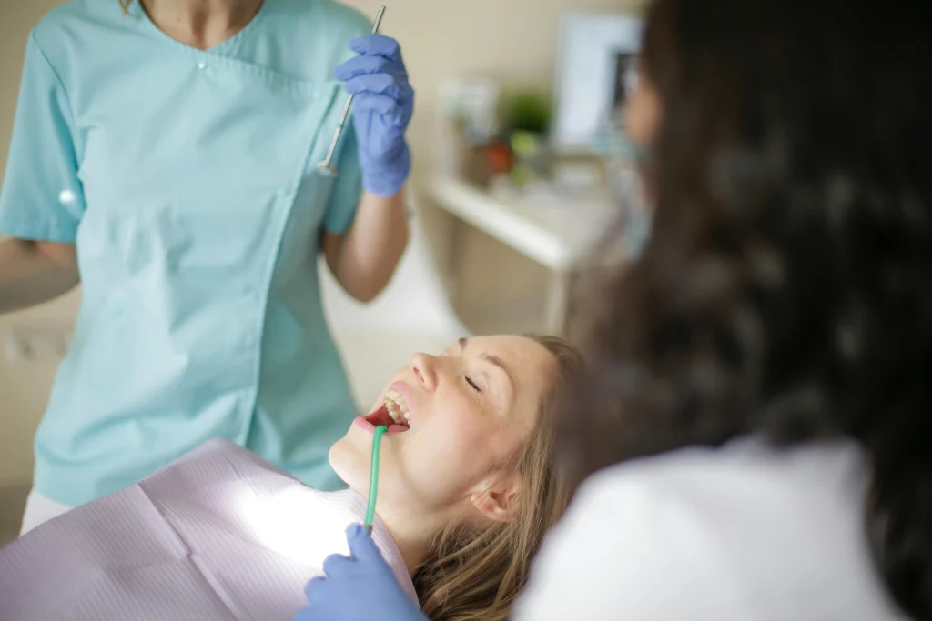 A patient lying down while a dentist performs a dental implant procedure, highlighting factors that affect how much are dental implants.