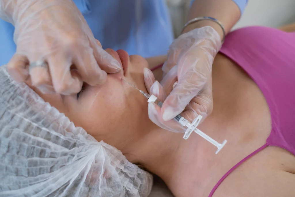 Expert applying botox injections on the cheeks to smooth expression lines and lift facial contours