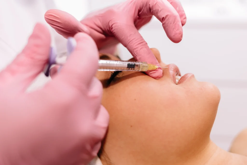 Expert applying botox injections on the cheeks to smooth expression lines and lift facial contours