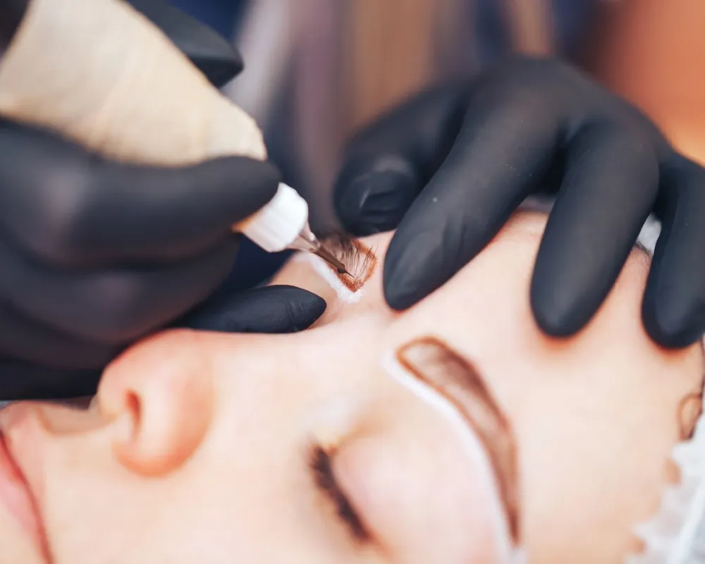 Close-up view of an eyebrow being treated with a digital machine for micropigmentation, showcasing pigment application and detail in the microblading vs micropigmentation debate