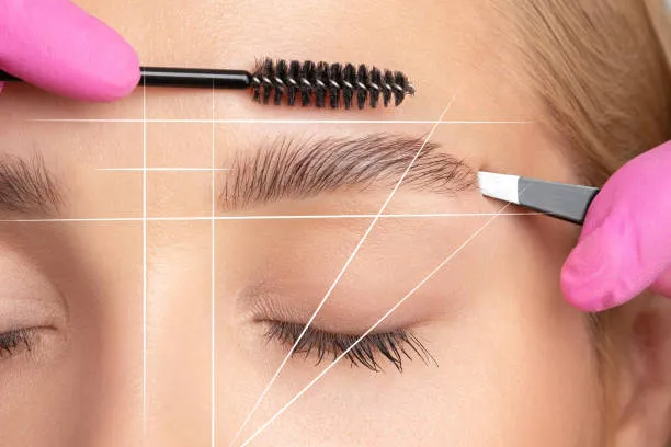 Specialist measuring a patient’s face to design the ideal eyebrow shape before performing a Microblading procedure.