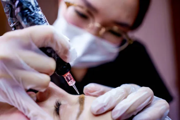 Doctor outlining and designing a patient’s eyebrows before starting the Microblading treatment.