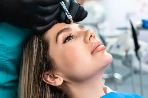 Specialist applying a PRP Injection between a patient’s eyebrows as part of a facial rejuvenation procedure.