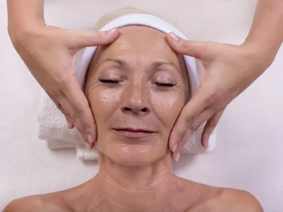 Front view of an older woman’s face showing natural aging signs before facelift, which is among the top plastic surgery procedures for facial rejuvenation