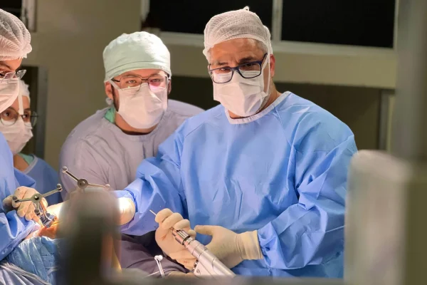 A team of surgeons performing a liposuction procedure in an operating room – understanding how much is liposuction depends on various factors like treatment areas and technique.